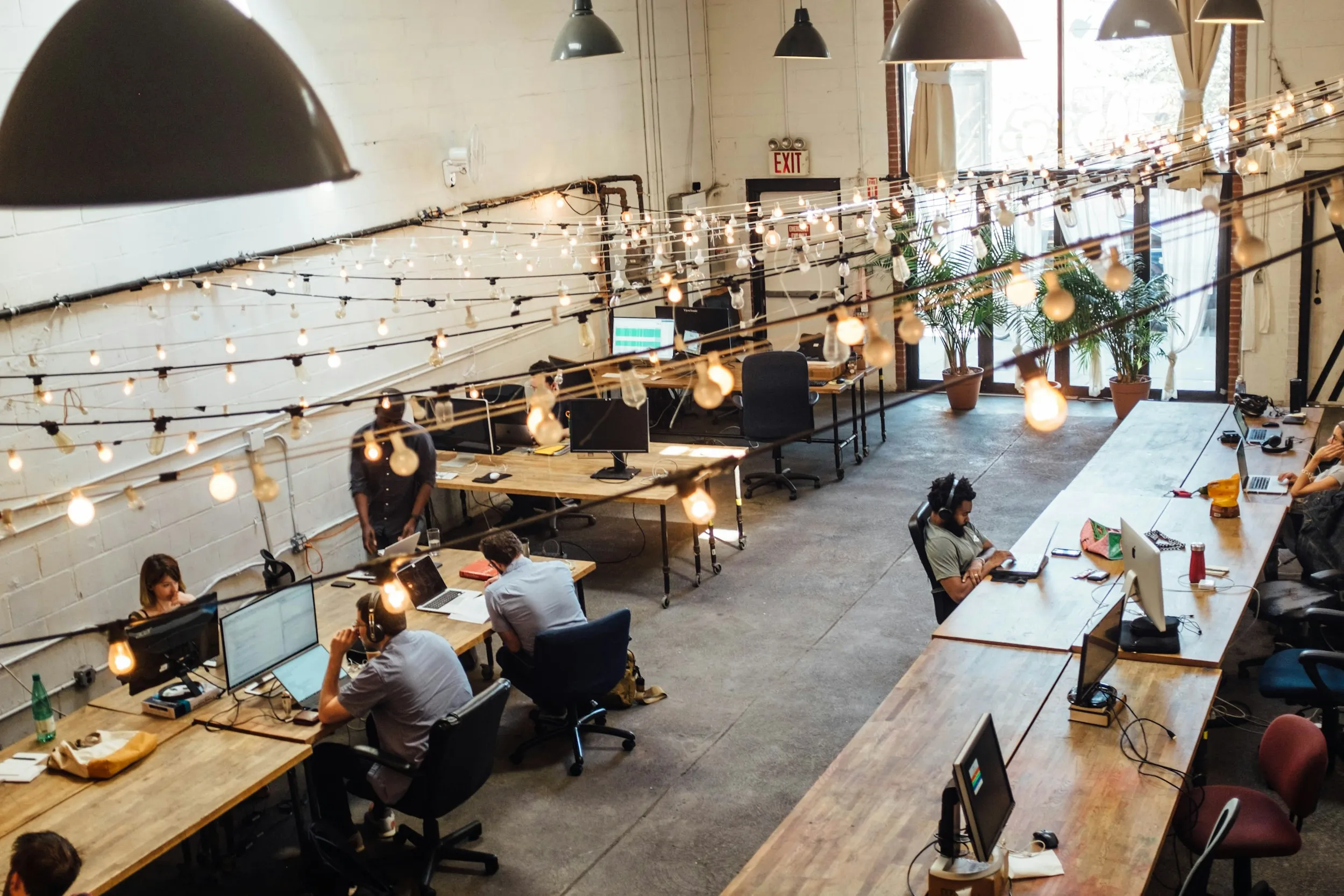 A modern, cozy co-working space with people working and chatting, representing a balanced and supportive work environment.